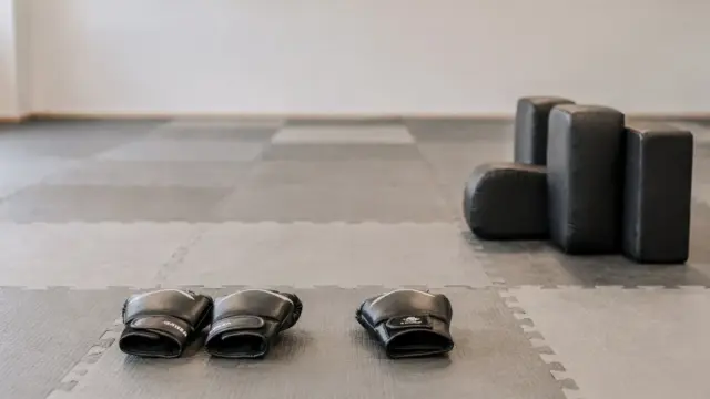 Zwei Trainingspartner üben Selbstverteidigungstechniken mit Abstand und Abwehr in einer hellen Trainingsumgebung.
