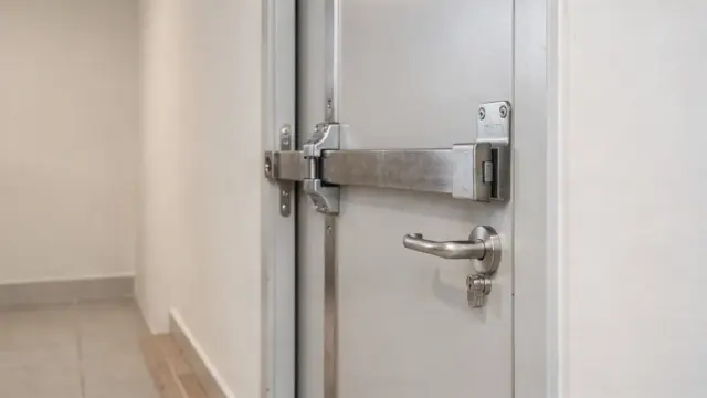 Querriegel an einer Wohnungstür als Einbruchschutz in einem hellen Flur