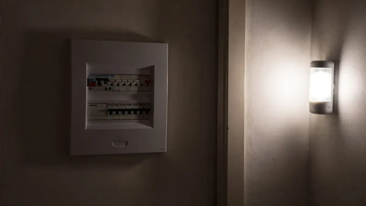 Verteilerkasten und Notlampe in einem dunklen Flur zum Thema Blackout oder Stromausfall