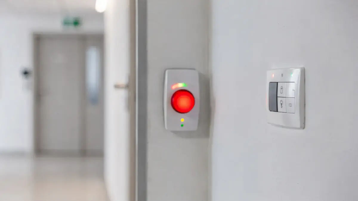 Panikalarm an einer Wand mit Steuerpanel in moderner Innenraumumgebung