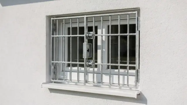 Gesichertes Kellerfenster mit Gitter und verstärktem Verschluss als Schutz vor Einbruch
